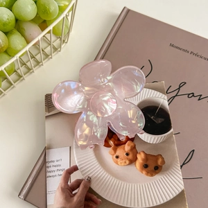 Détail d'une grande pince à cheveux fleur rose irisée avec pétales transparents