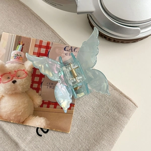 Détail de la pince à cheveux papillon bleu clair irisé avec un fini nacré élégant