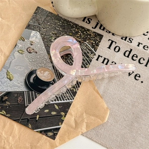 Detail of 13cm oversized iridescent pink acetate hair claw clip with knot design