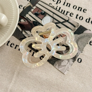 Detail of butterfly hair claw with iridescent mother-of-pearl finish and gold metal spring