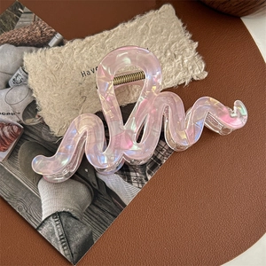Détail d'une pince à cheveux sirène avec finition irisée et texture en résine rose
