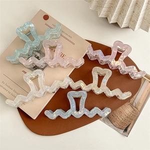 Iridescent oversized wave hair claw clips with heart detail in multiple pastel colors