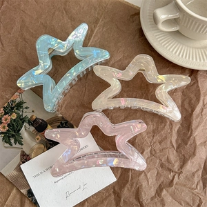 Three hollow star-shaped hair claws in iridescent blue, cream, and pink colors