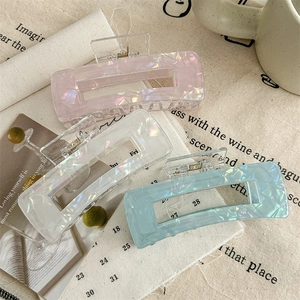 Three large acrylic marble hair claws in pink, blue, and white for elegant hair styling