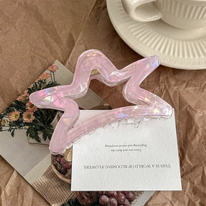 Detailed view of large translucent star hair claw clip with iridescent pearlescent finish