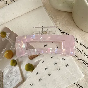 Detail shot of large square hair claw with holographic pink marble texture and hollow design
