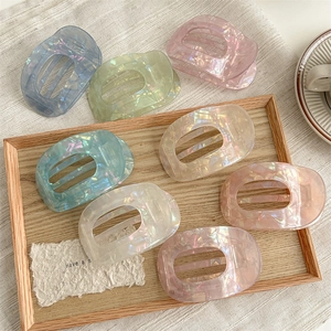 Iridescent acetate hair claw clips set in semicircular design with shell pearl texture