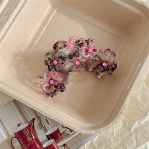 Dettaglio della pinza per capelli a fiore con trama marmorizzata e perline rosa