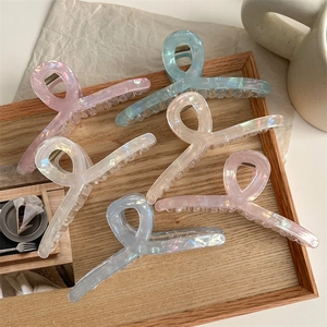 Set of 6 minimalist iridescent large hair clips in various pastel colors on a wooden tray