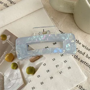 Macro detail of a large rectangular acrylic hair claw with blue marble texture