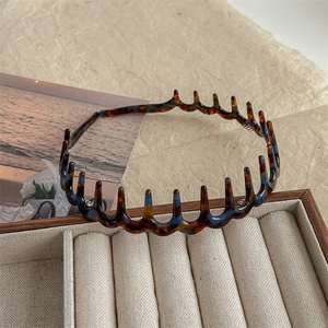 Close-up of tortoise shell wavy headband with teeth for hair styling and volume
