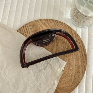 Detail view of deep brown semi-circular shark clip featuring gold France Handmade lettering