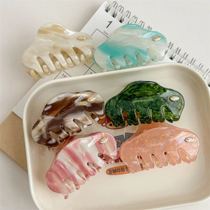 Elegant wave-shaped acetate hair claw clips in marble patterns and pearl finishes