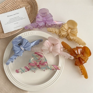 Large acetate bow hair claws in six elegant colors including cream, lilac, and amber
