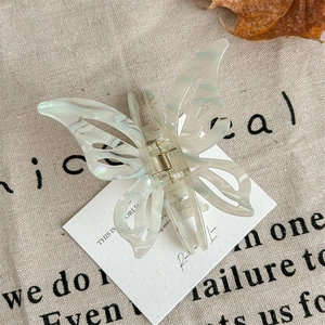 Detailed view of the butterfly claw clip with elegant pearlescent texture and gold spring