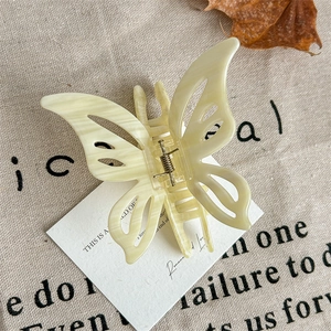 Macro detail of elegant marble butterfly hair claw clip on rustic linen and dry leaf