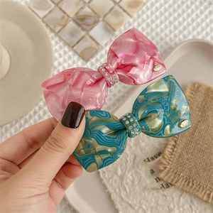 Elegant bow hair clips with marble texture, sparkling rhinestones and golden accents