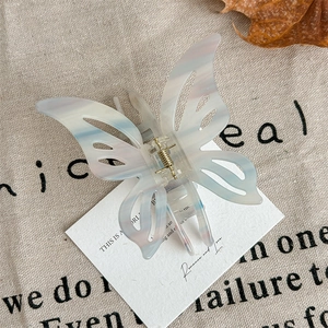 Detail of elegant butterfly hair claw clip with marble texture on textile background