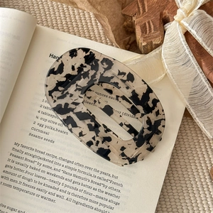 Detailaufnahme einer Haarklammer aus Acetat mit Schildpattmuster auf Vintage-Buch
