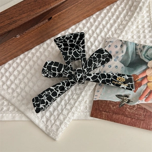 Detailed macro view of handmade pink bow claw clip with black white marble texture