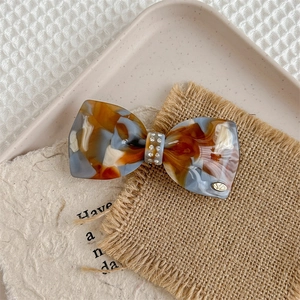 Detail of luxury acetate bow hair clip with tortoiseshell pattern and sparkling rhinestones