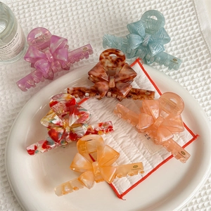 Elegant bow hair claws in six colors including purple and tortoiseshell finish