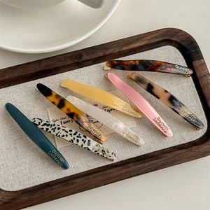 Set of 7 French style acetate hair clips with gold label and various marble patterns
