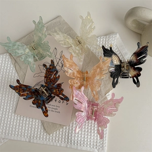 Lot de six pinces à cheveux papillon colorées en pastel sur un fond esthétique et doux