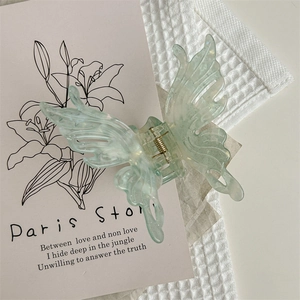 Détail d'une pince à cheveux papillon vert menthe avec paillettes sur tissu gaufré