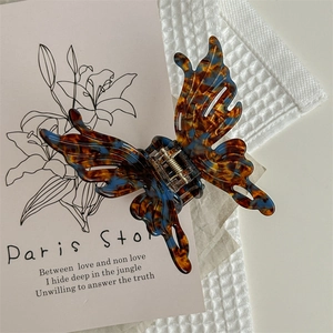 Détail d'une pince à cheveux papillon avec texture marbrée brune et bleue sur tissu