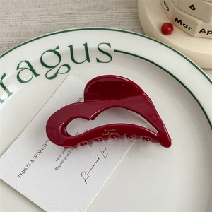 Macro view of burgundy heart-shaped acetate hair claw with gold Barette La France lettering