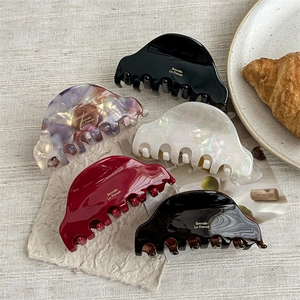 French style acetate hair claw clips in five elegant colors on a rustic fabric background