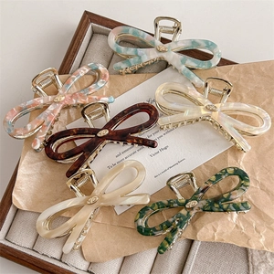 Elegant acetate bow hair claws with tortoise and marble patterns for women's hairstyling