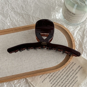 Detail of tortoise shell hair claw clip with golden France Handmade logo on tray