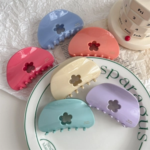 Set of six macaron-colored acetate hair claws with flower cutout and gold lettering