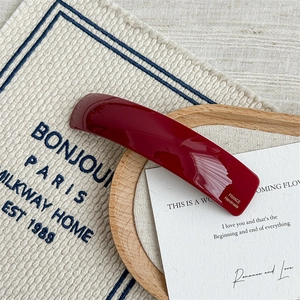Detail of burgundy acetate hair clip featuring gold France Handmade lettering