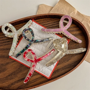 Elegant large metal shark hair clips with marble patterns set in wooden tray