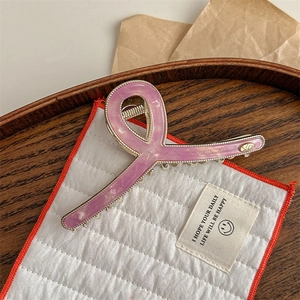 Detailed view of lavender resin bow hair claw with gold metal edges for elegant hairstyles