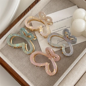 Elegant gradient butterfly hair claws in iridescent pearl white, mint, lavender, and pink