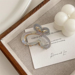 Detail view of small gradient butterfly hair claw with golden metal spring mechanism