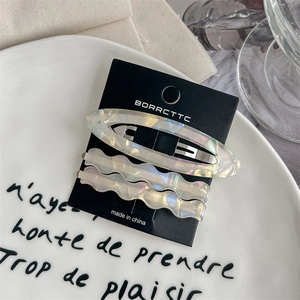 Vue détaillée de 3 barrettes en acétate avec finition nacrée sur carte de présentation