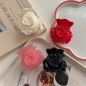 Pinces à cheveux roses élégantes en quatre couleurs sur un plateau blanc décoratif