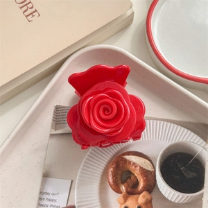 Gros plan sur une pince à cheveux rose rouge brillante sur un plateau au style français
