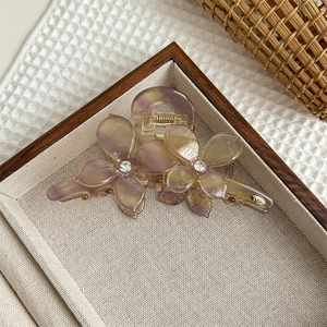 Vue détaillée d'une pince à cheveux florale en résine dégradé violette avec des strass