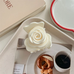 Gros plan détaillé d'une pince à cheveux rose blanc crème sur fond de style vintage