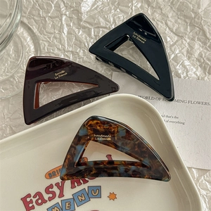 Minimalist acetate triangle hair claws set in black, tortoise shell, and brown colors