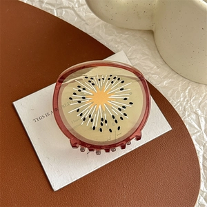 Détail de la pince à cheveux motif kiwi en acétate translucide au style créatif