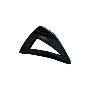 Minimalist black triangle hair claw with gold handmade lettering on a white background