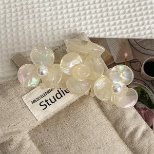Detail of floral acetate hair claw clip with pearlescent finish and center pearls