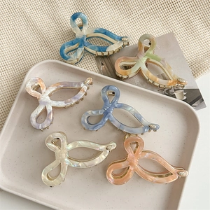 6-piece set of acetate claw clips with marble textures on a ceramic tray display